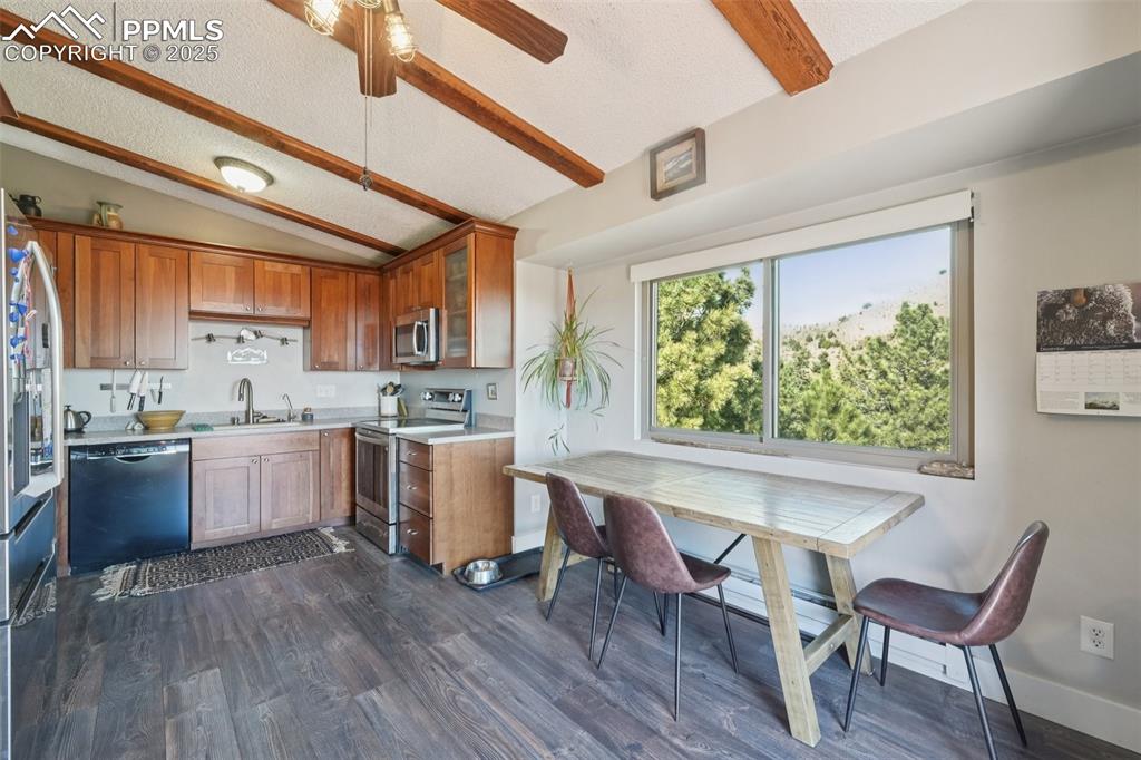 975 Crystal Park Road Manitou Springs, CO 80829 - Photo 8 of 38 a kitchen with a stove a sink dishwasher white refrigerator a dining table and chair with wooden floor