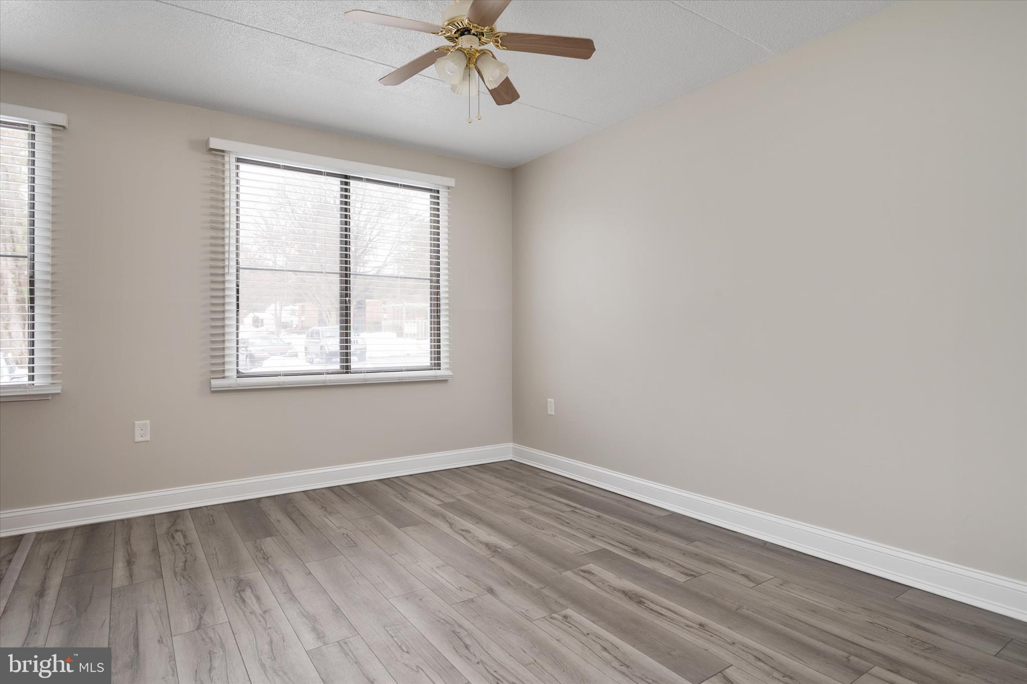 5245 West Running Brook Road, Unit 101 Columbia, MD 21044 - Photo 12 of 33 an empty room with wooden floor fan and windows