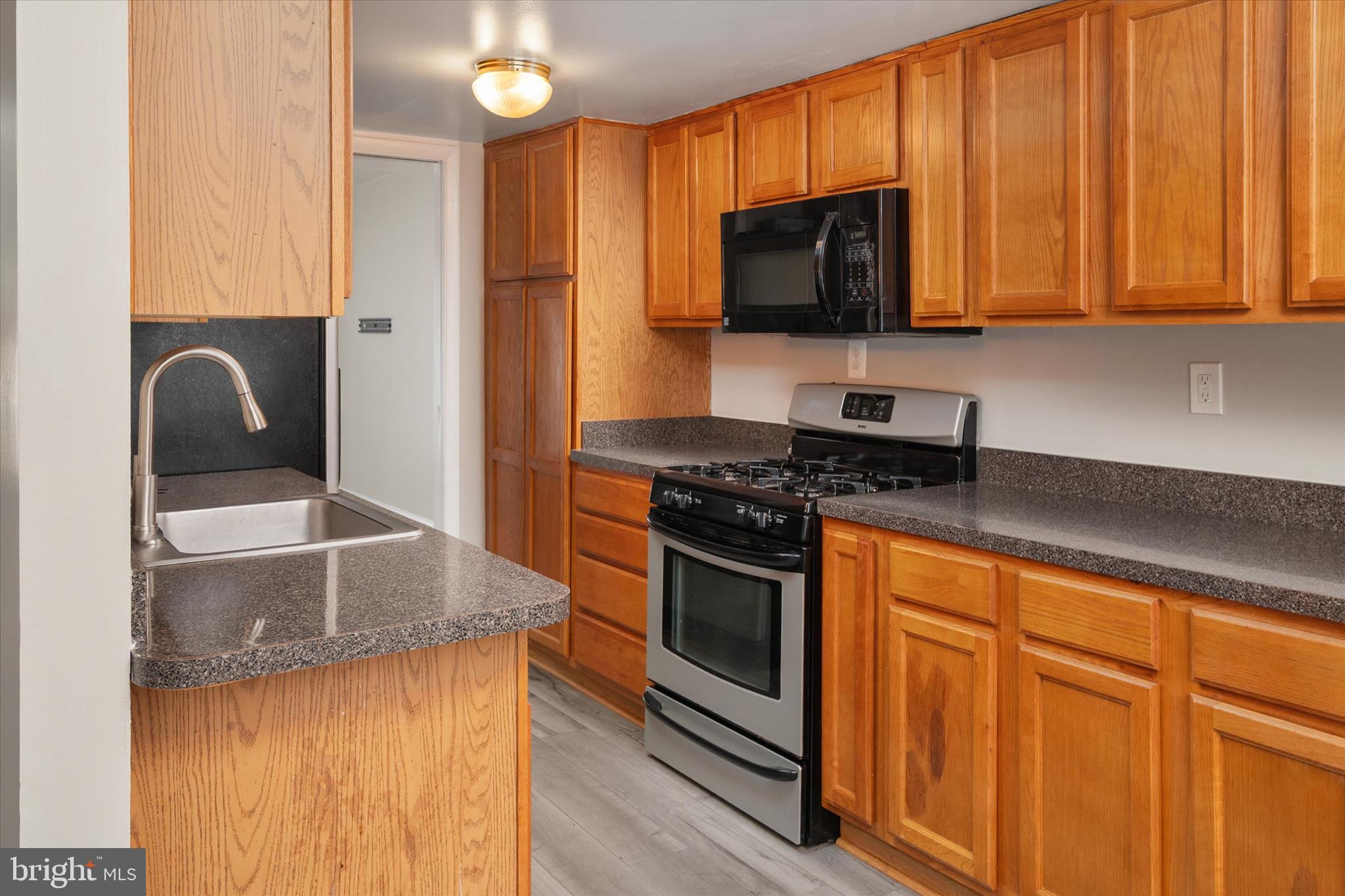 5245 West Running Brook Road, Unit 101 Columbia, MD 21044 - Photo 15 of 33 a kitchen with stainless steel appliances granite countertop a stove a sink and a microwave