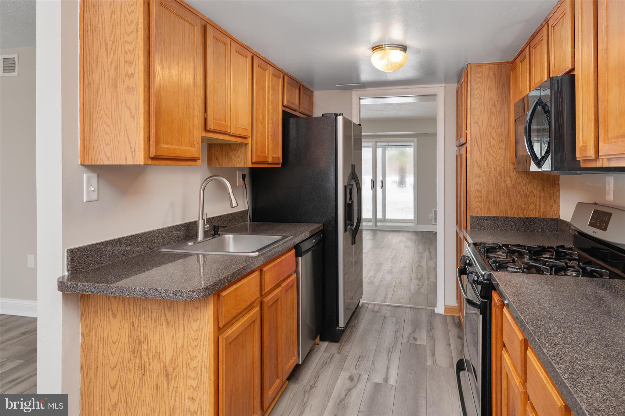 5245 West Running Brook Road, Unit 101 Columbia, MD 21044 - Photo 16 of 33 a kitchen with stainless steel appliances granite countertop a sink stove and refrigerator