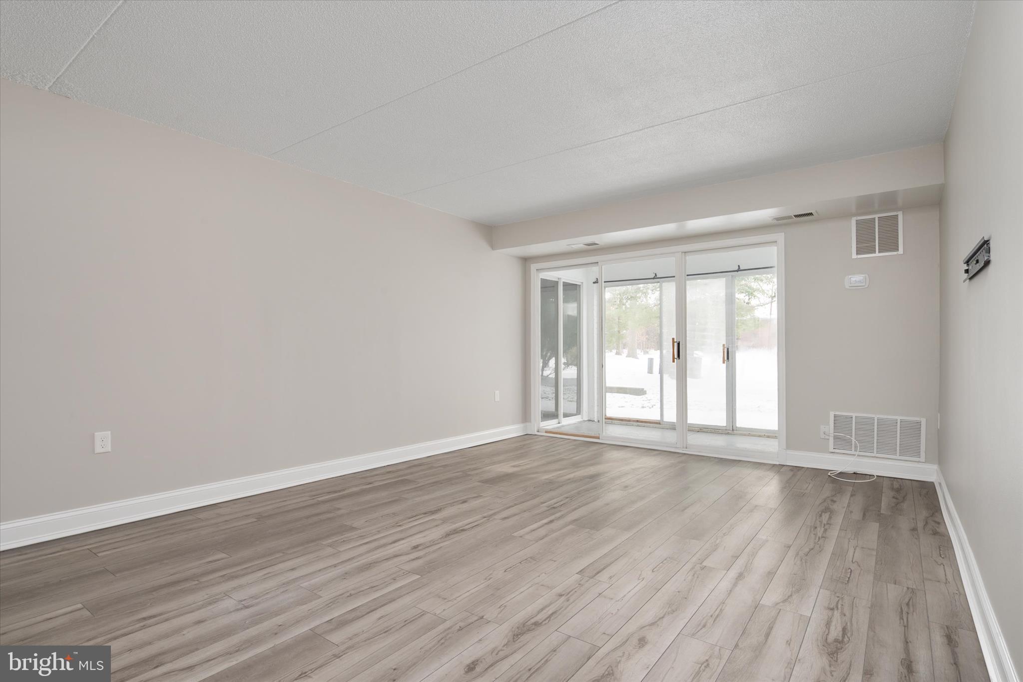 5245 West Running Brook Road, Unit 101 Columbia, MD 21044 - Photo 7 of 33 a view of an empty room with wooden floor and a window