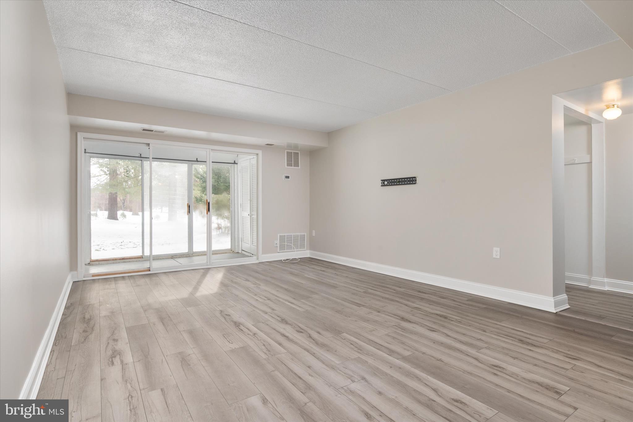 5245 West Running Brook Road, Unit 101 Columbia, MD 21044 - Photo 8 of 33 wooden floor in an empty room with a window