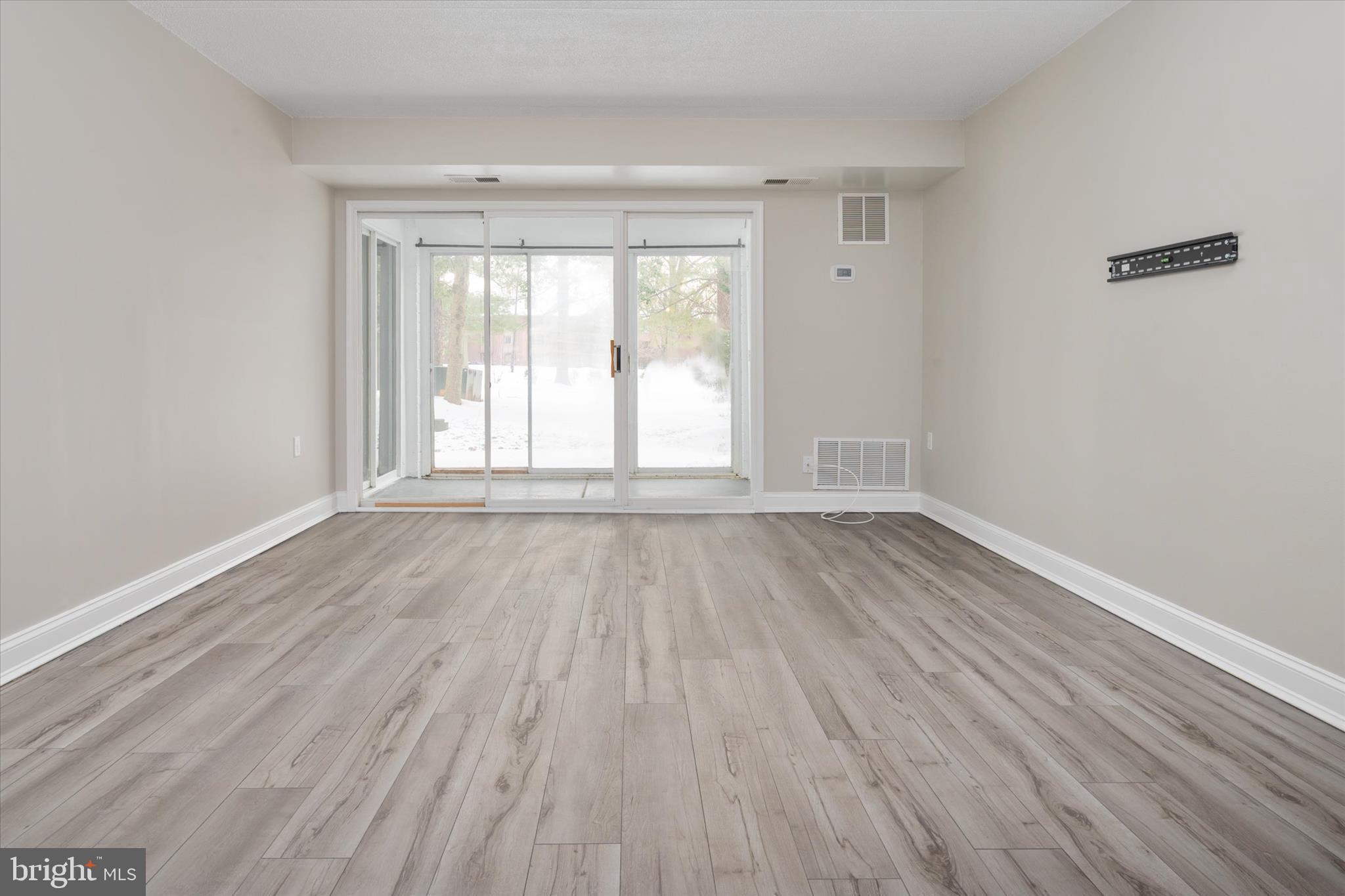 5245 West Running Brook Road, Unit 101 Columbia, MD 21044 - Photo 9 of 33 an empty room with wooden floor and windows