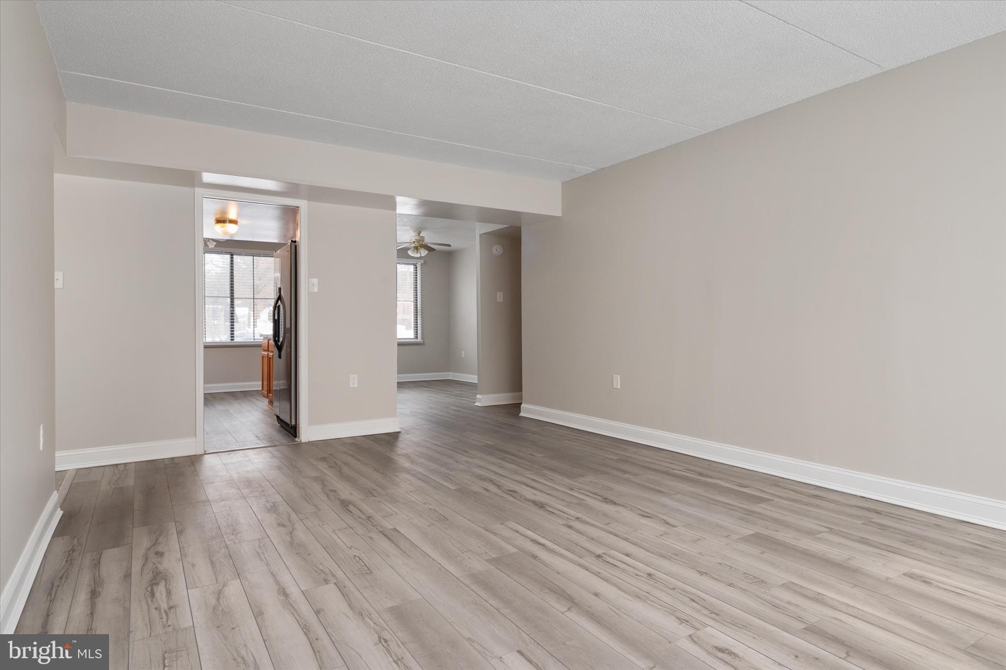 5245 West Running Brook Road, Unit 101 Columbia, MD 21044 - Photo 10 of 33 a view of an empty room with window and wooden floor