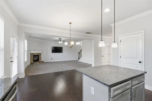 a kitchen with a stove a counter space and wooden floor