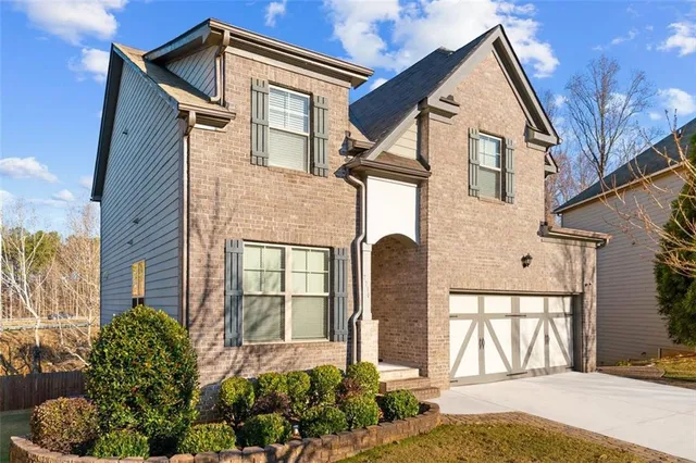 a front view of a house with a garden