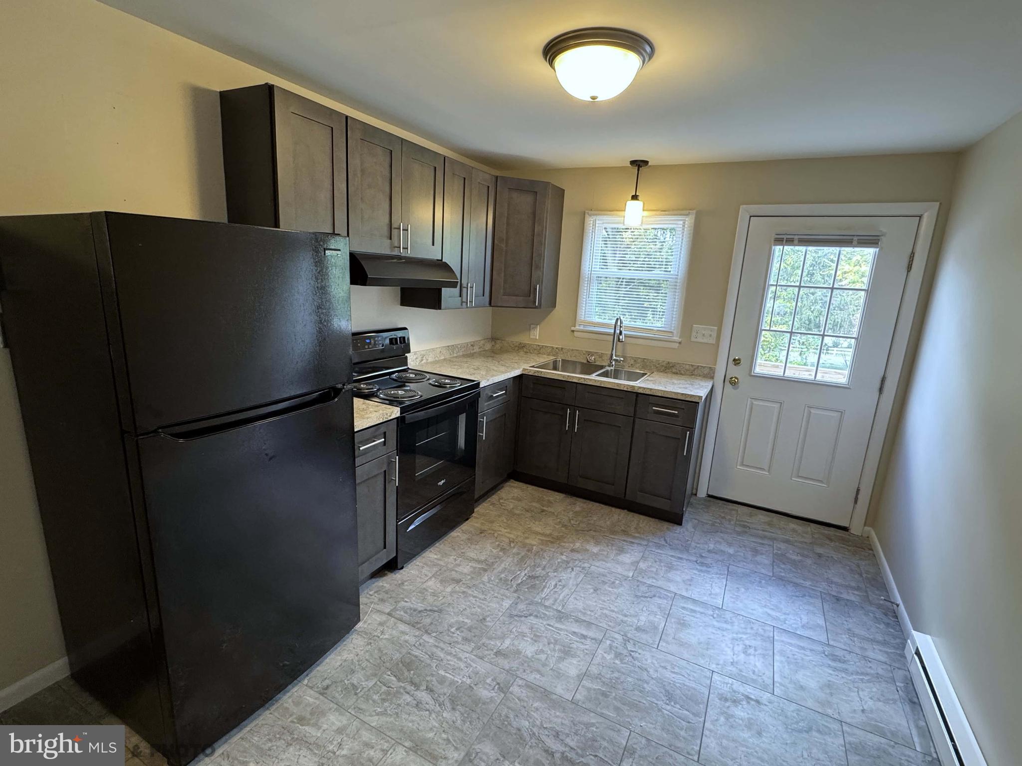 6570 Somerset Street, Unit 2 Harrisburg, PA 17111 - Photo 2 of 9 a kitchen with stainless steel appliances granite countertop a refrigerator a sink a stove a microwave and island