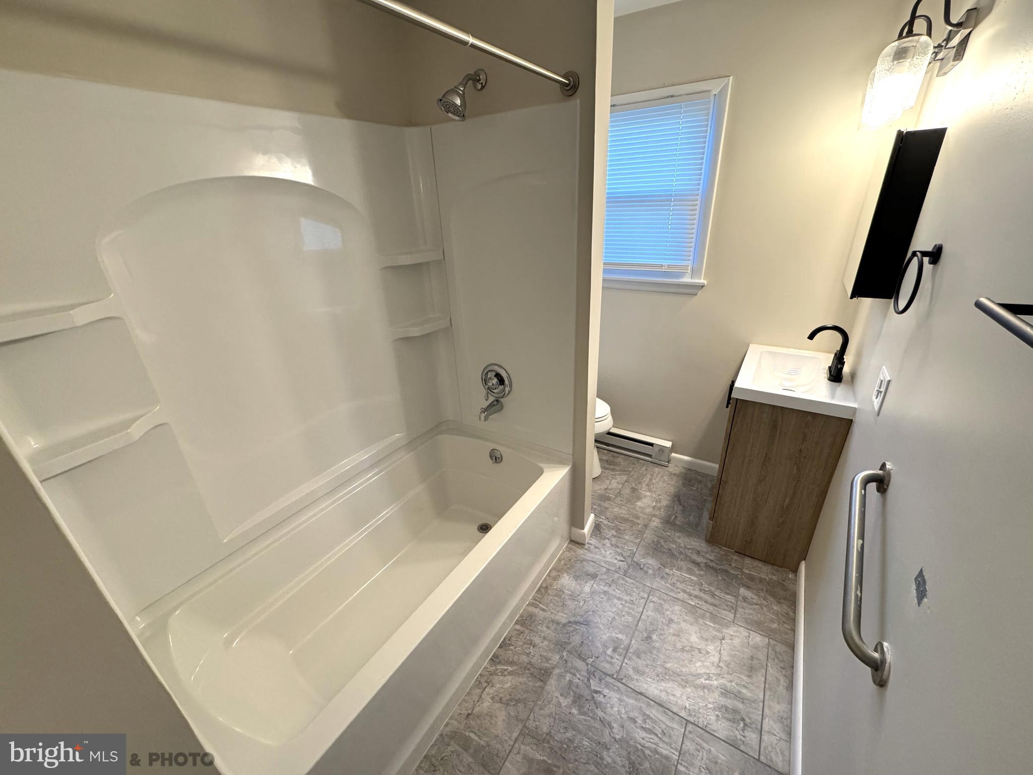 6570 Somerset Street, Unit 2 Harrisburg, PA 17111 - Photo 5 of 9 a bathroom with a tub a sink and wooden floor