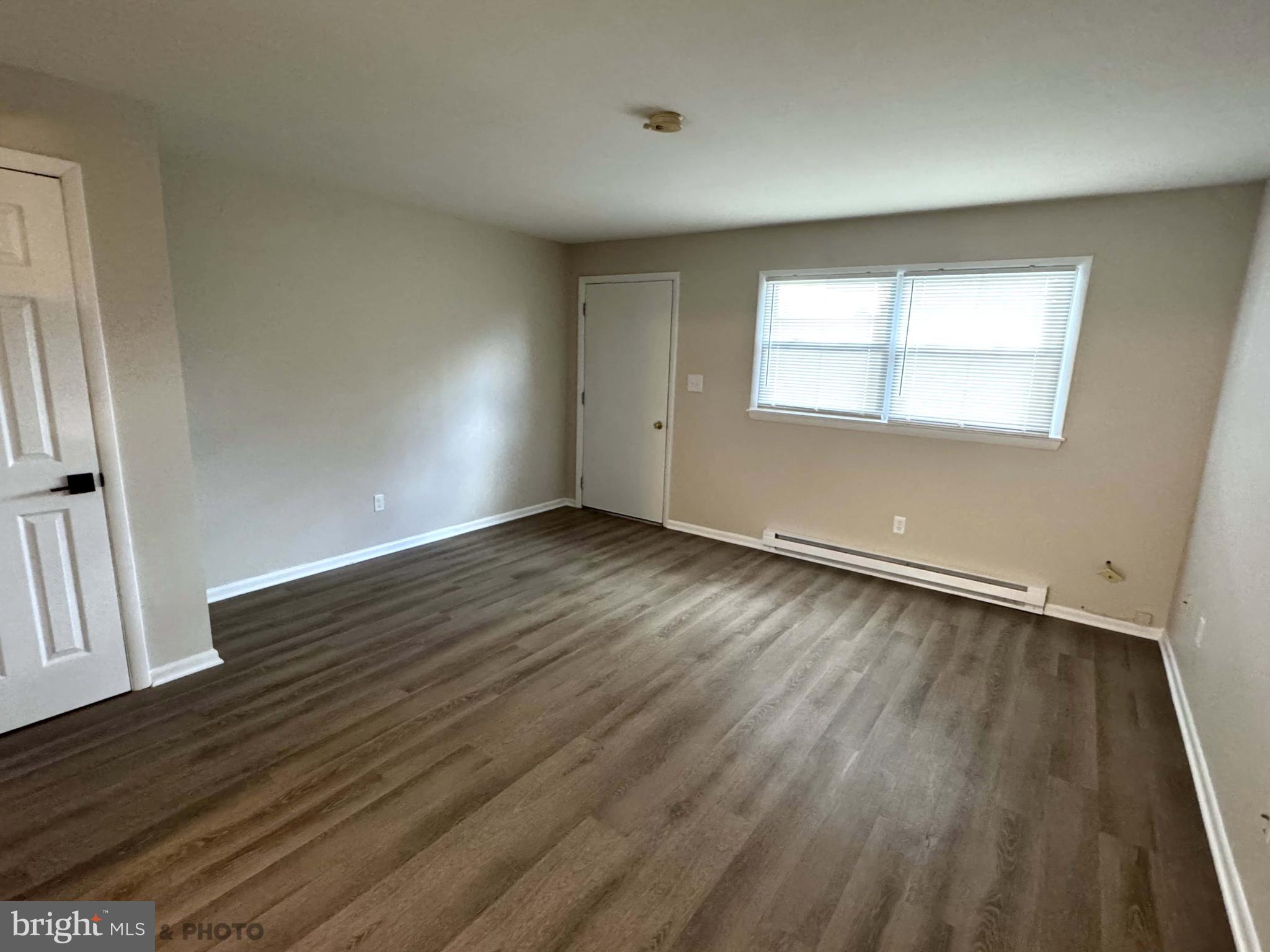 6570 Somerset Street, Unit 2 Harrisburg, PA 17111 - Photo 9 of 9 an empty room with wooden floor and windows