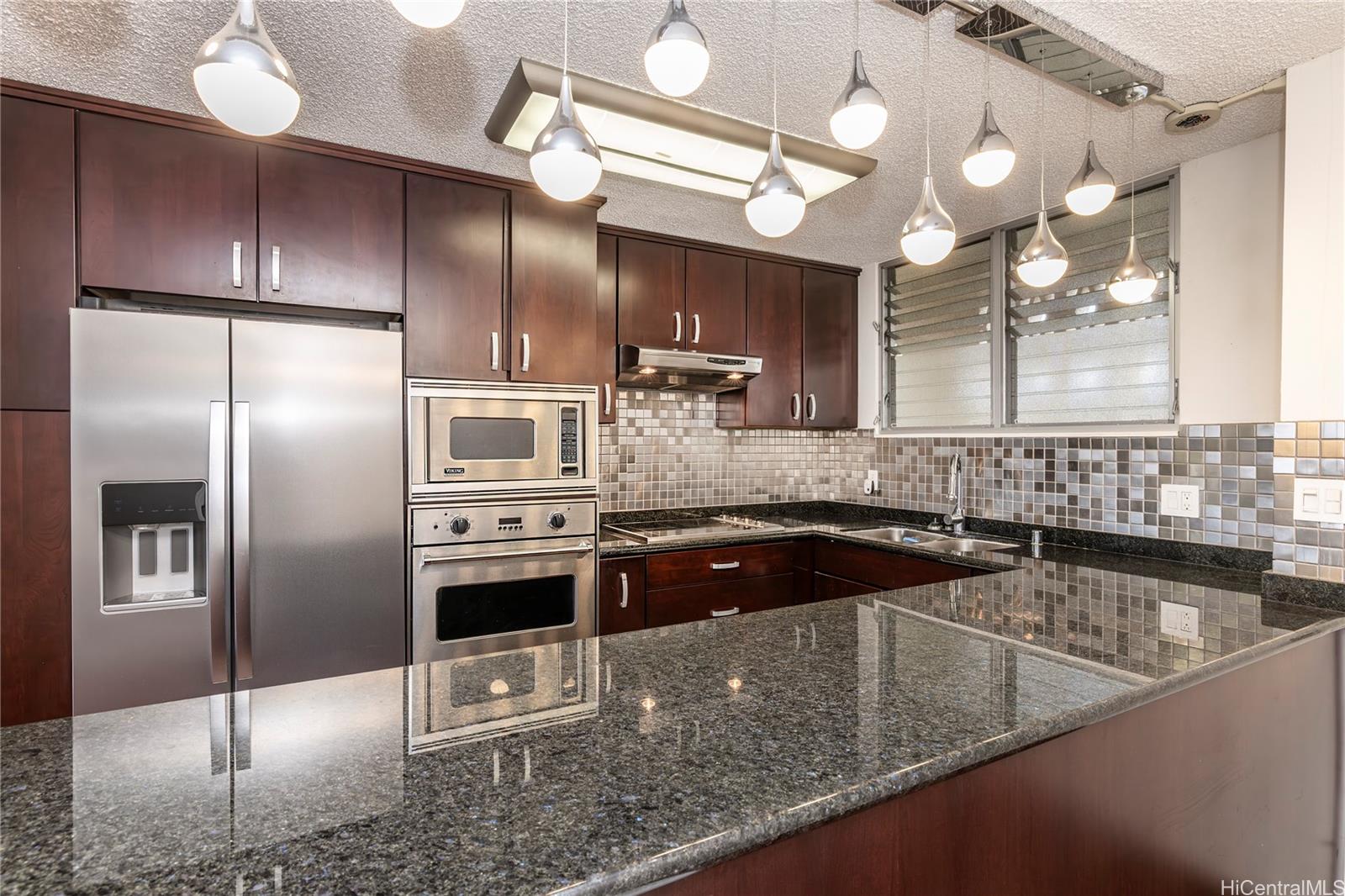 469 Ena Road, Unit 2205 Honolulu, HI 96815 - Photo 4 of 21 a kitchen with stainless steel appliances granite countertop a sink a stove and a refrigerator