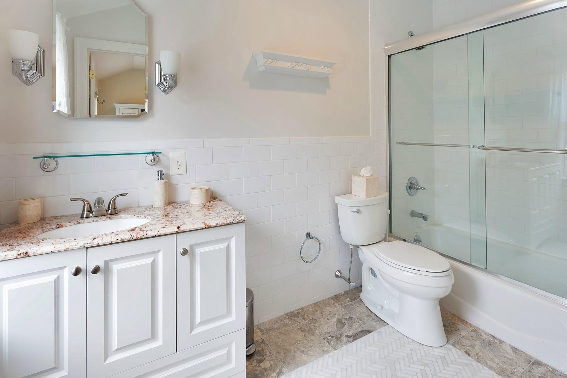 337 Brookside Road Darien, CT 06820 - Photo 18 of 35 a bathroom with a granite countertop sink a toilet a mirror and shower