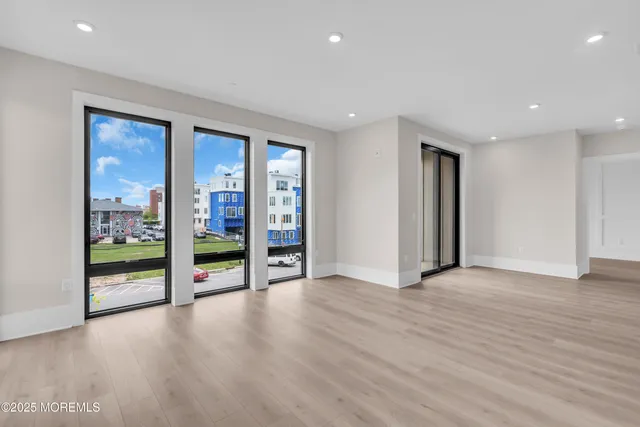 an empty room with wooden floor and balcony