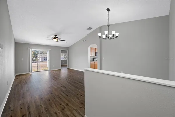 a view of a livingroom with wooden floor and a chandelier