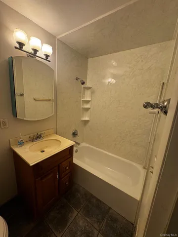 a bathroom with a tub sink and mirror