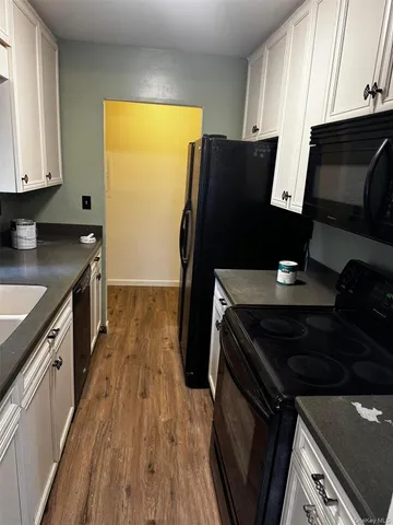 a kitchen with granite countertop a stove and a wooden floor