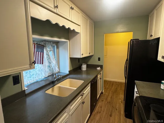 a kitchen with kitchen island a counter top space a sink a stove and a refrigerator