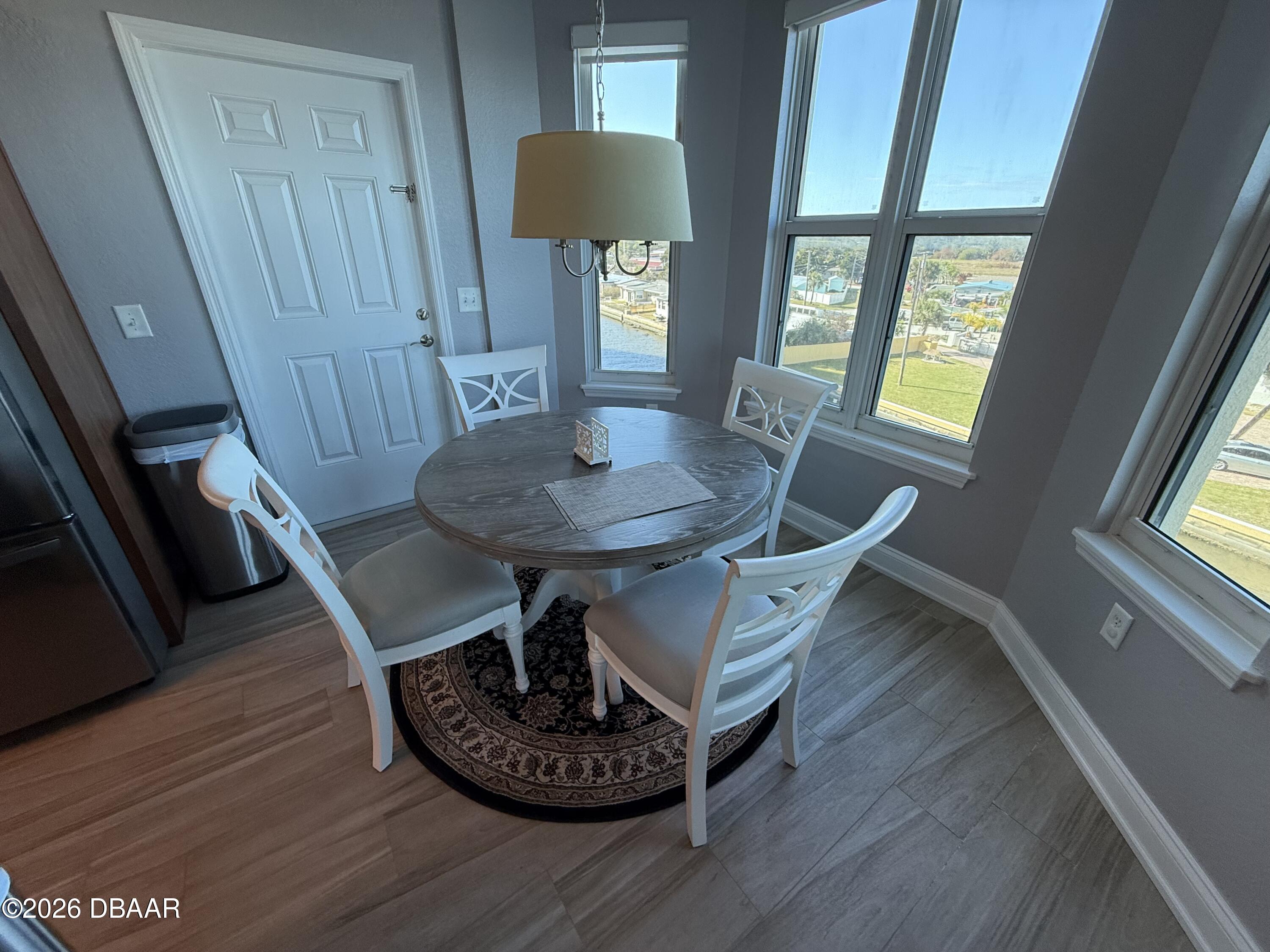 2801 South Ridgewood Avenue, Unit 409 South Daytona, FL 32119 - Photo 8 of 23 a view of a dining room with furniture window and wooden floor