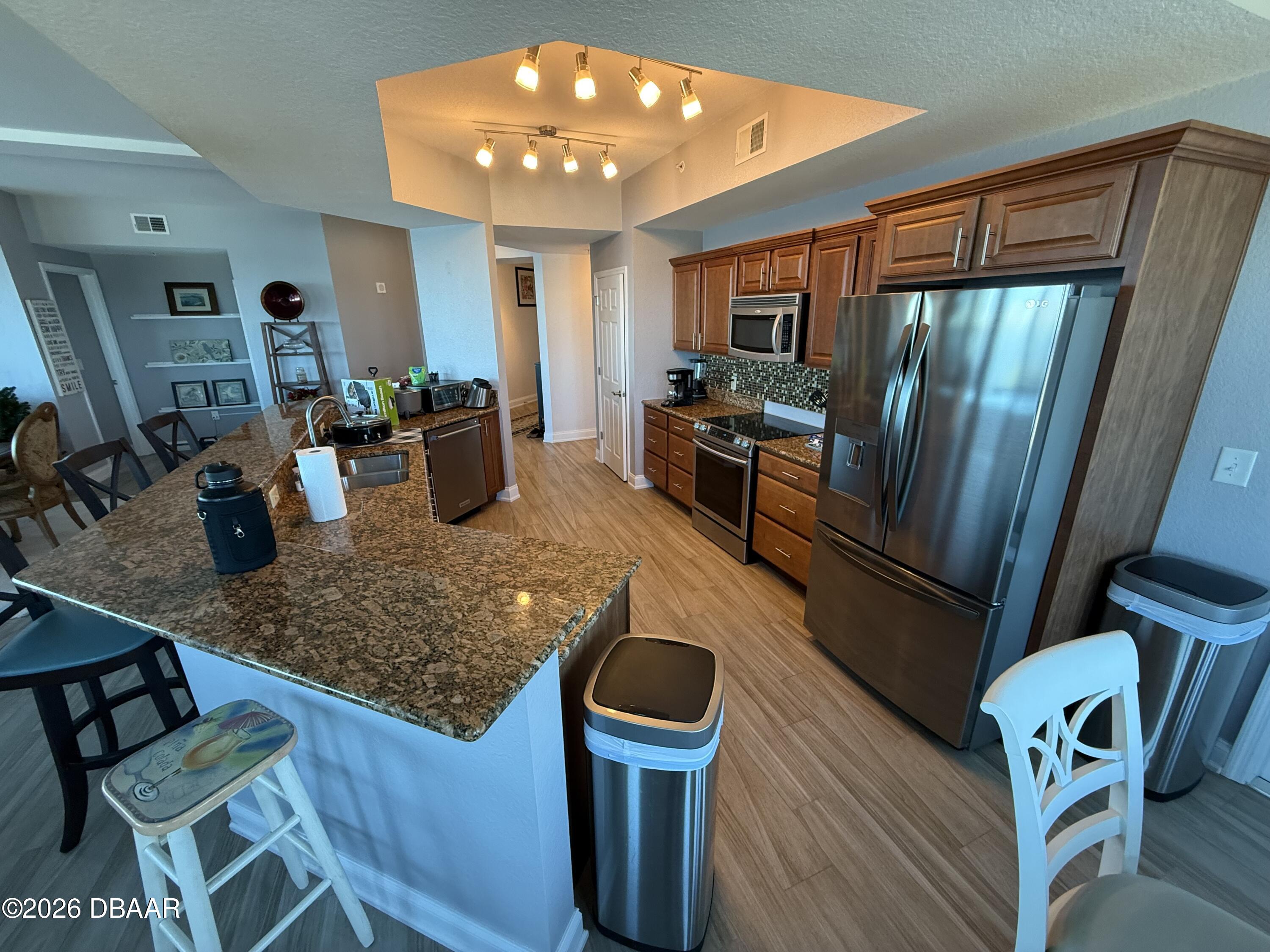2801 South Ridgewood Avenue, Unit 409 South Daytona, FL 32119 - Photo 9 of 23 a kitchen with sink refrigerator dining table and chairs