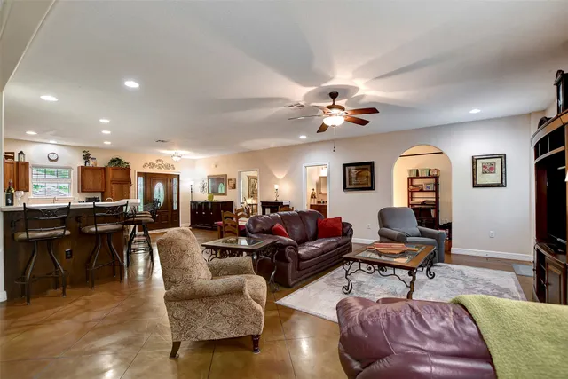 a living room with furniture kitchen view and a chandelier