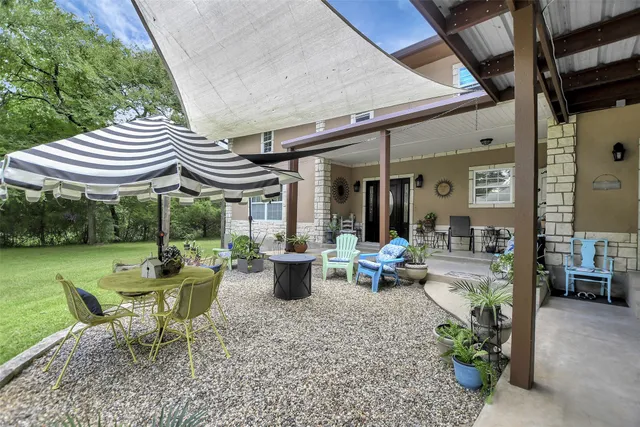 a view of a patio with table and chairs potted plants with floor to ceiling window