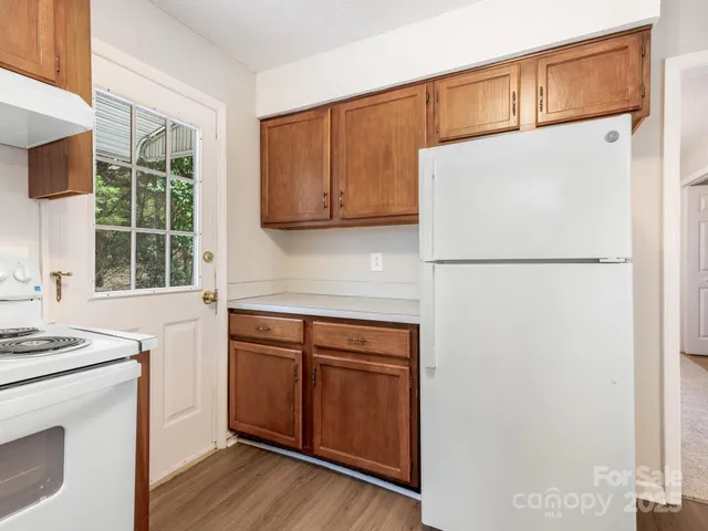 a kitchen with a white stove top oven sink and cabinets