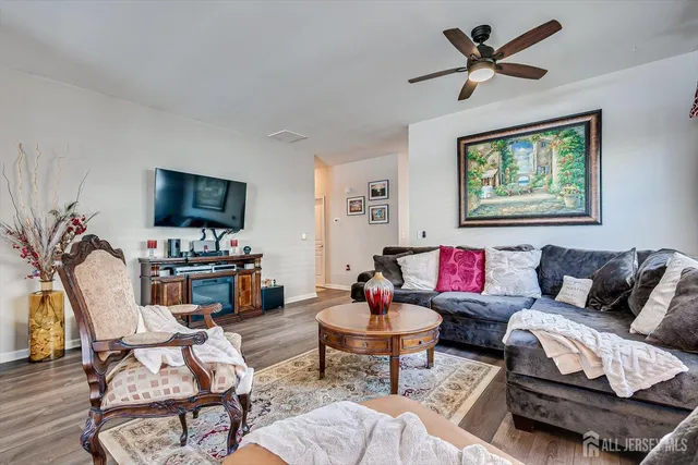 a living room with furniture a flat screen tv and a window