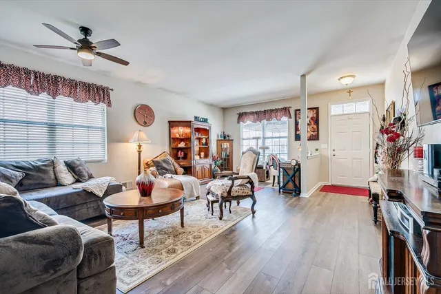 a living room with furniture kitchen view and a window