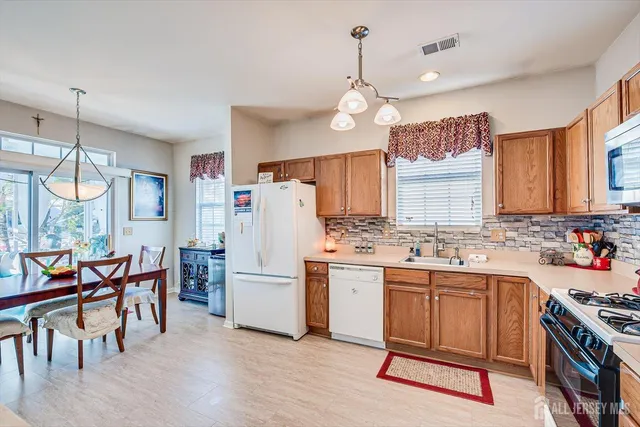 a kitchen that has a lot of cabinets in it and stainless steel appliances