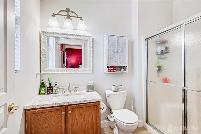 a bathroom with a granite countertop toilet sink and mirror