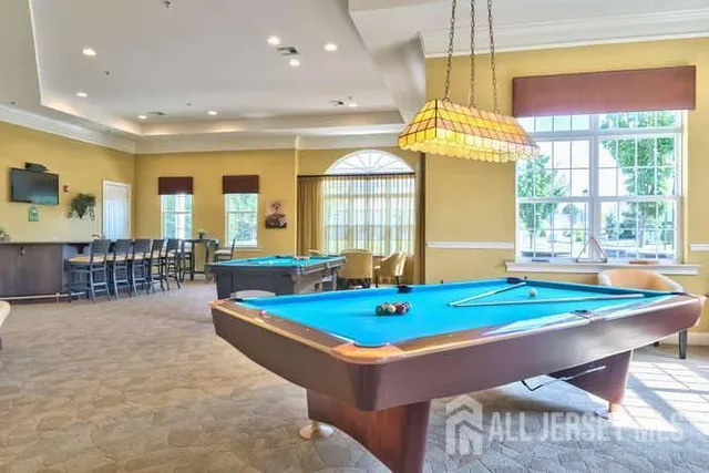 a room with pool table and windows