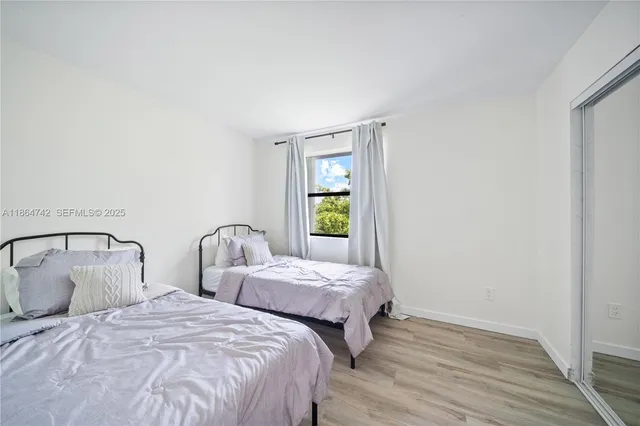 a bedroom with two beds and a window