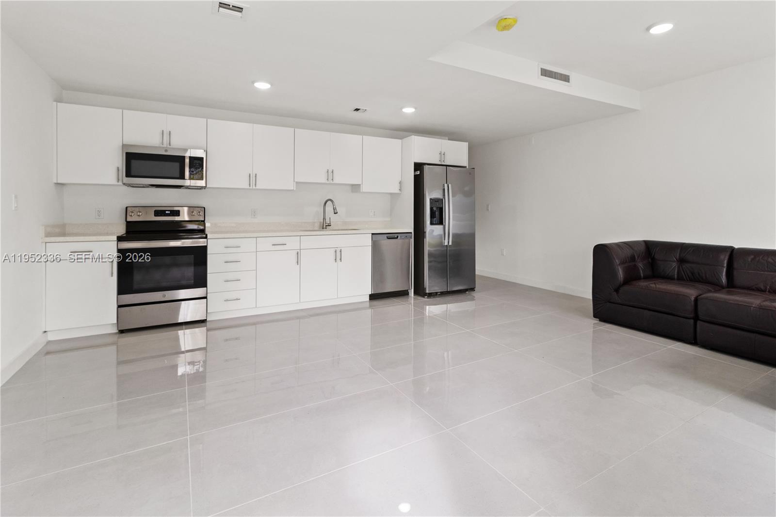 14571 Southwest 261st Street Homestead, FL 33032 - Photo 13 of 30 a kitchen with stainless steel appliances kitchen island granite countertop a refrigerator stove top oven and sink