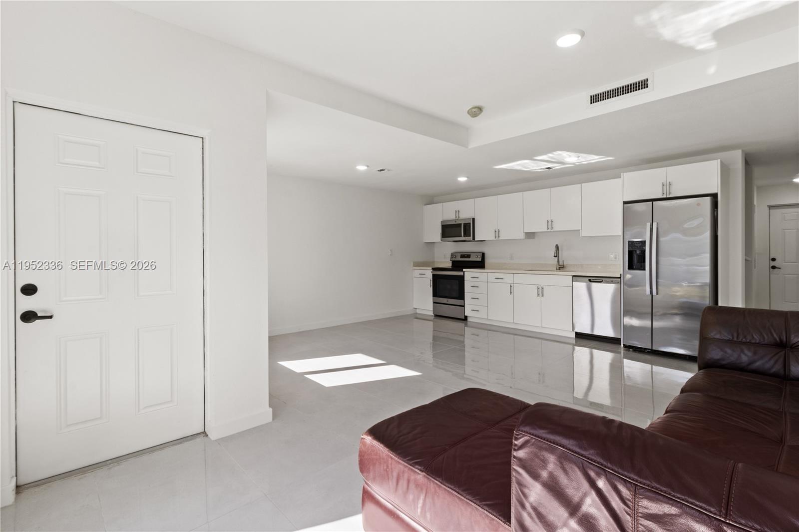 14571 Southwest 261st Street Homestead, FL 33032 - Photo 10 of 30 a living room with stainless steel appliances kitchen island granite countertop a refrigerator and cabinets
