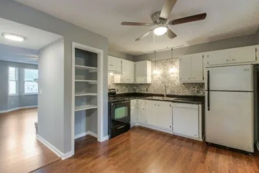 a kitchen with granite countertop stainless steel appliances a refrigerator and a stove top oven