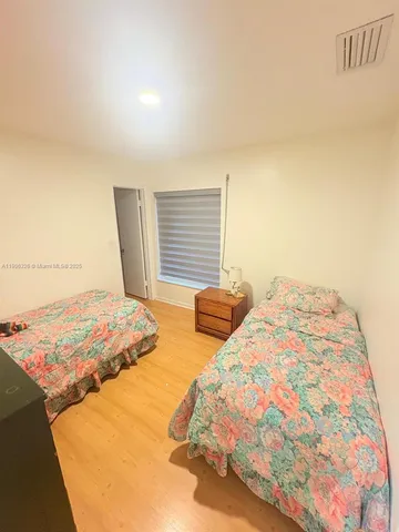 a bedroom with two beds and painting on the wall