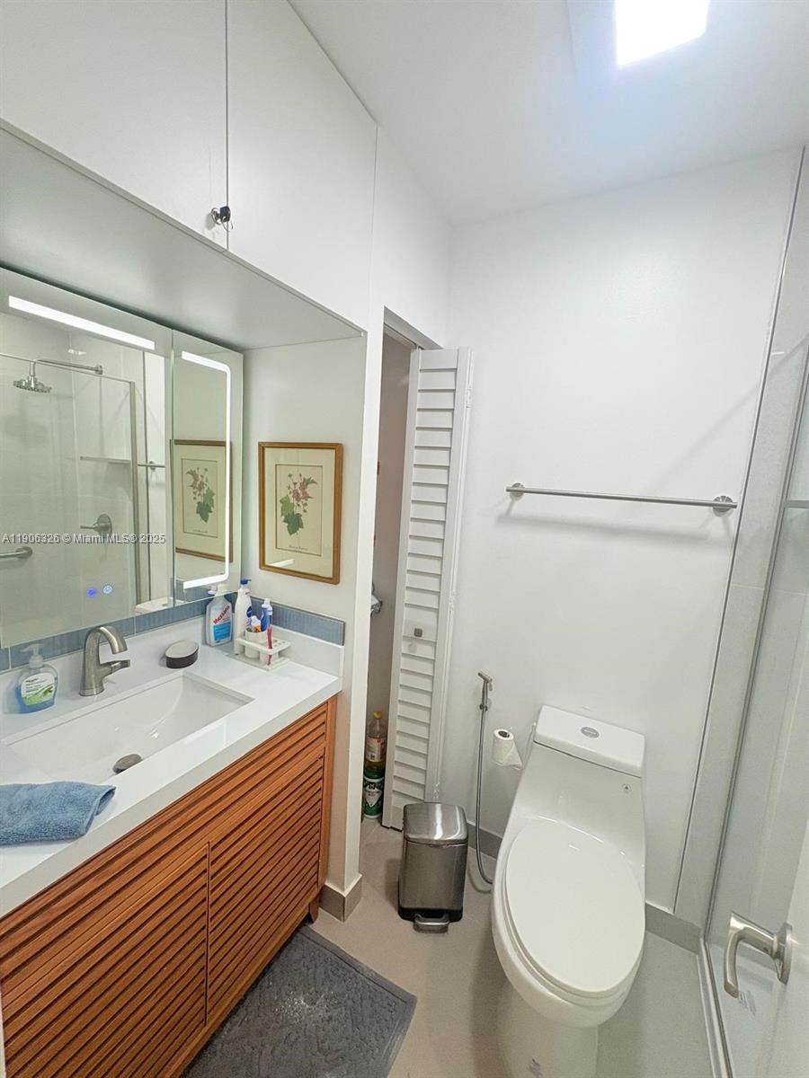 927 Northwest 106th Ave Circle Miami, FL 33172 - Photo 14 of 24 a bathroom with a granite countertop toilet sink and mirror