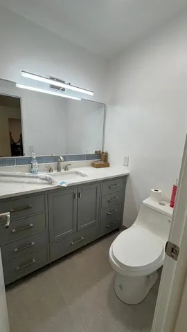 a white toilet sitting next to a bathroom sink