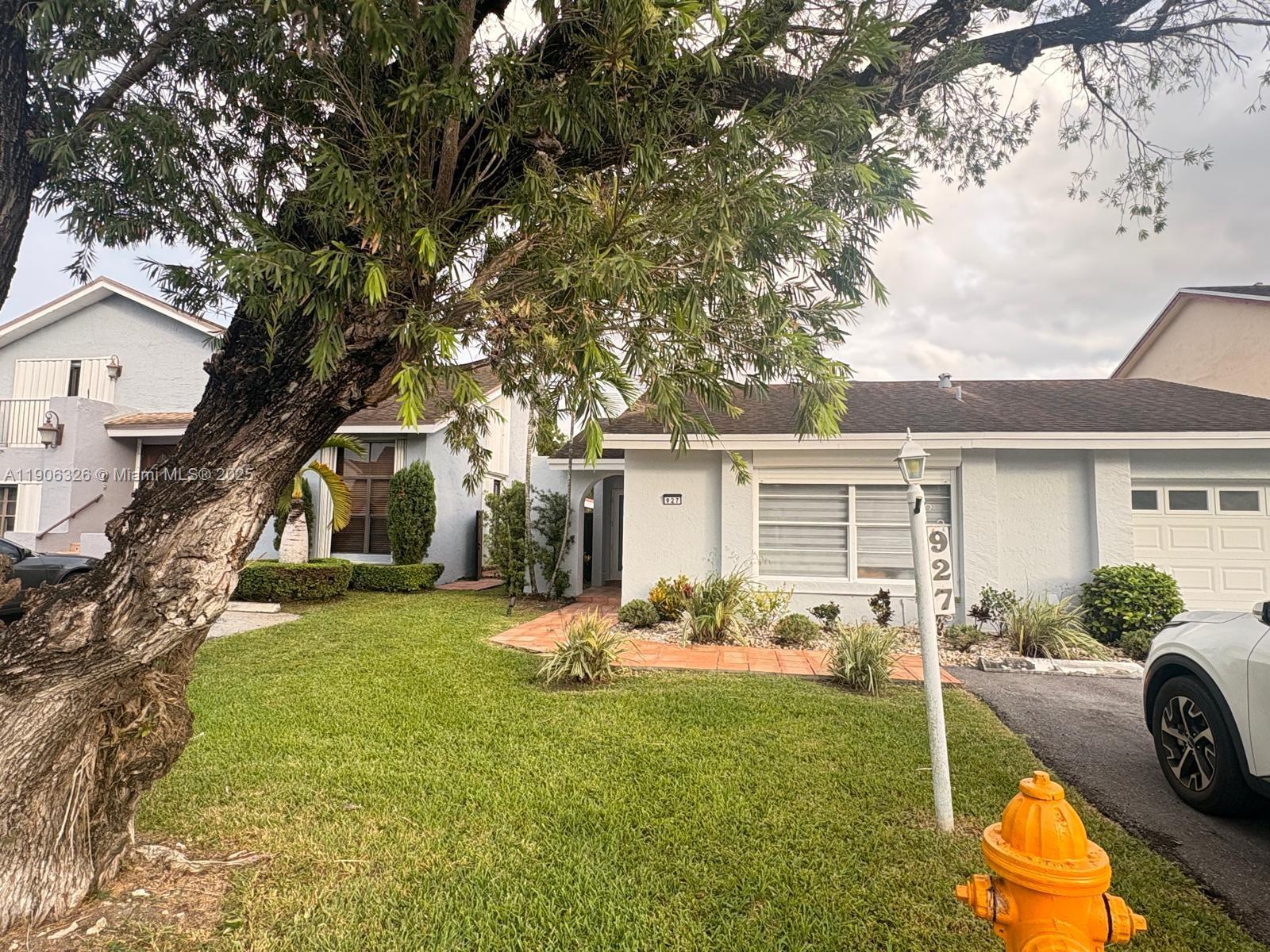 927 Northwest 106th Ave Circle Miami, FL 33172 - Photo 3 of 24 a view of a backyard with table and chairs potted plants and a large tree