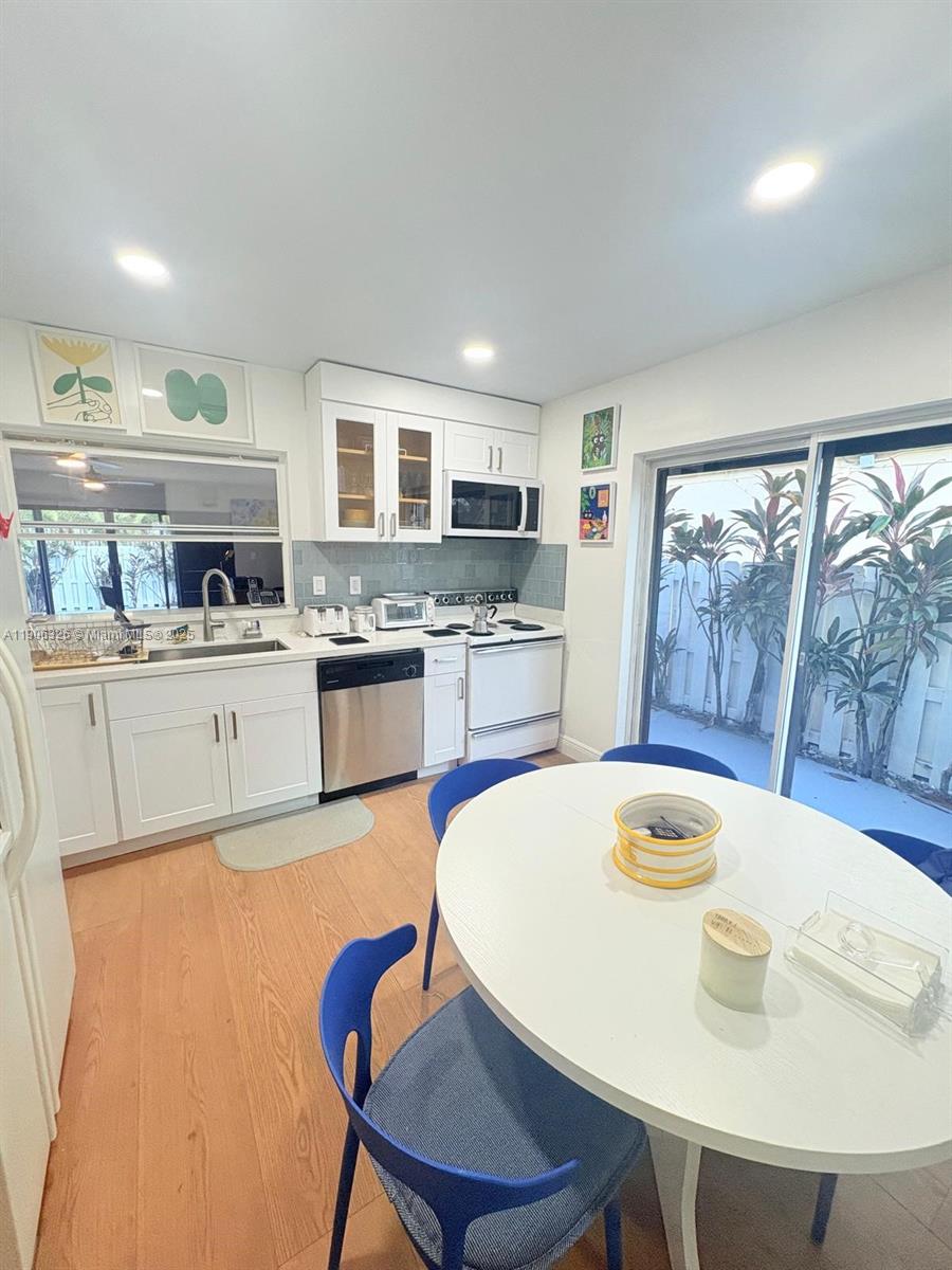 927 Northwest 106th Ave Circle Miami, FL 33172 - Photo 5 of 24 a kitchen with a table chairs a stove a dining table and chairs