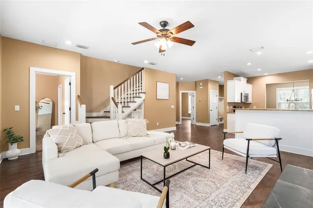 a living room with furniture and a view of kitchen