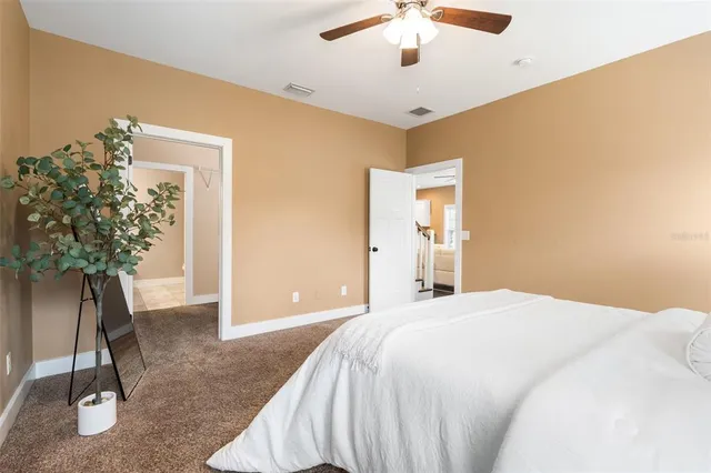 a bedroom with a bed and a potted plant