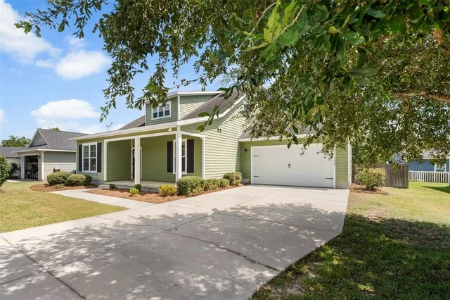 a front view of a house with a yard and potted plants
