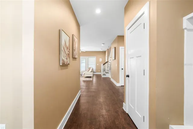 a view of a hallway with wooden floor and a living room