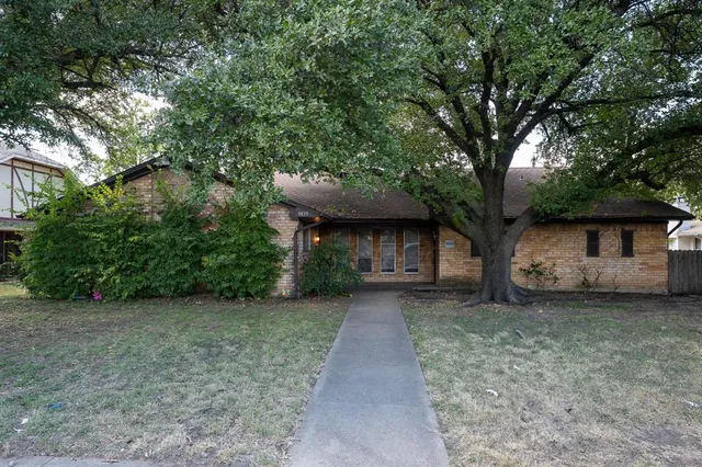 a view of a house with a large tree and a big yard