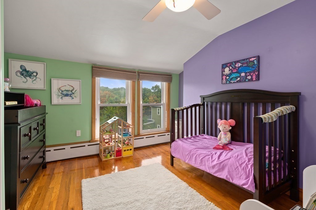20 Butler Street Medford, MA 02155 - Photo 24 of 29 a bedroom with a bed and wooden floor