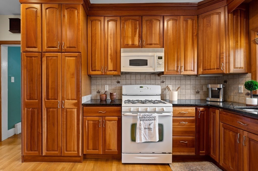20 Butler Street Medford, MA 02155 - Photo 5 of 29 a kitchen with stainless steel appliances granite countertop wooden cabinets a sink and a refrigerator