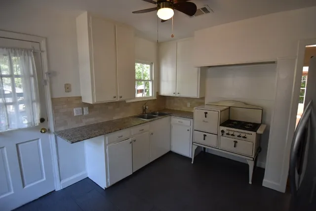 a kitchen with stainless steel appliances granite countertop a sink a refrigerator and a stove