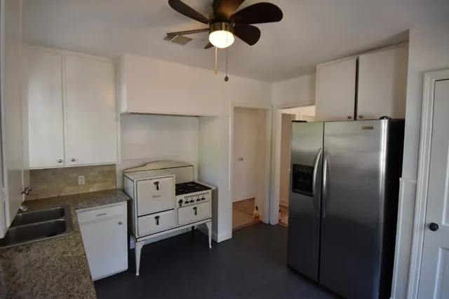 a front view of a house with a yard covered with snow and trees
