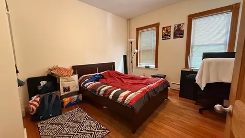 a bedroom with a bed and wooden floor