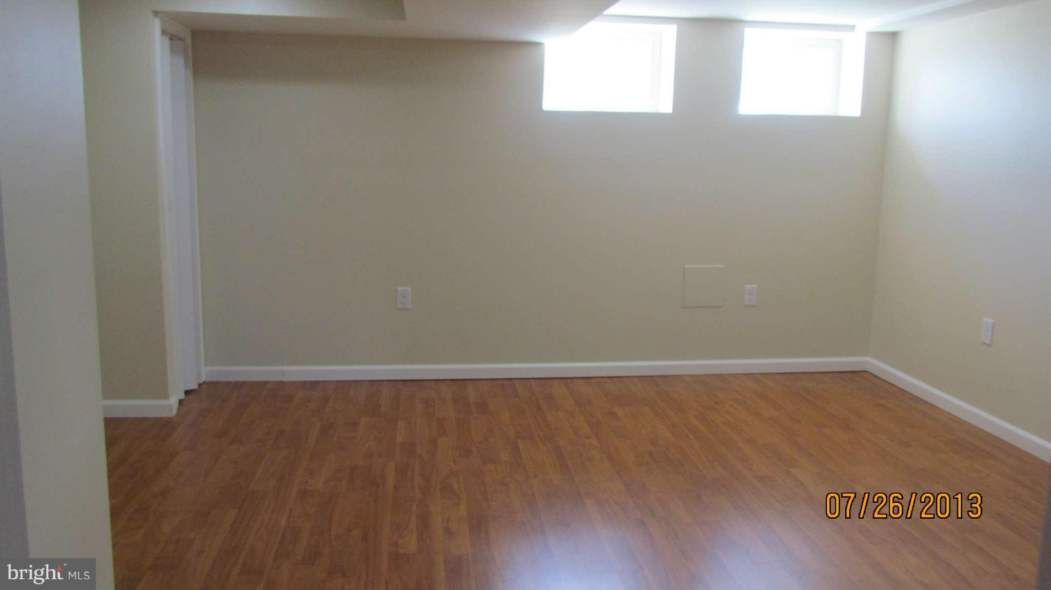 2233 Searles Road Baltimore, MD 21222 - Photo 12 of 15 a view of an empty room with wooden floor and a window